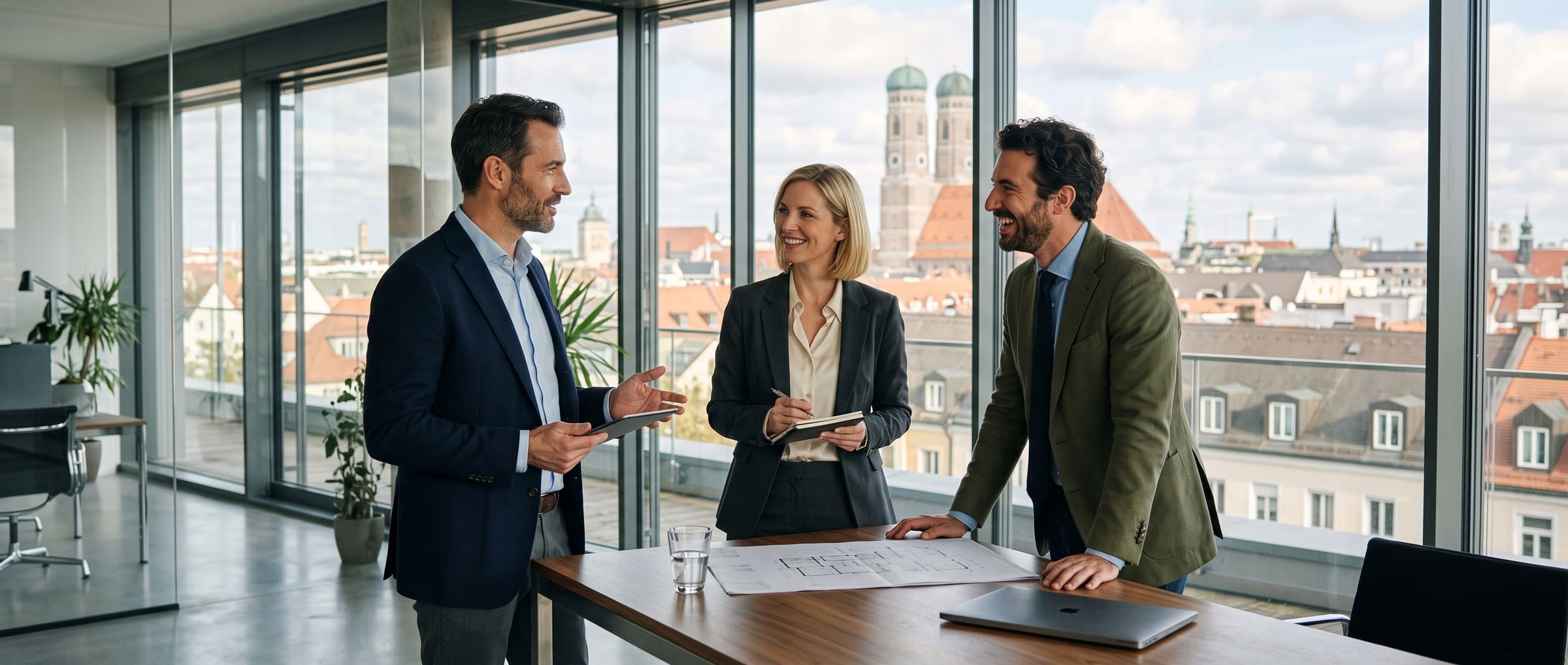 Drei Partner im Gespräch in einem modernen Büro über den Dächern Münchens – Partnerschaft für Generationen